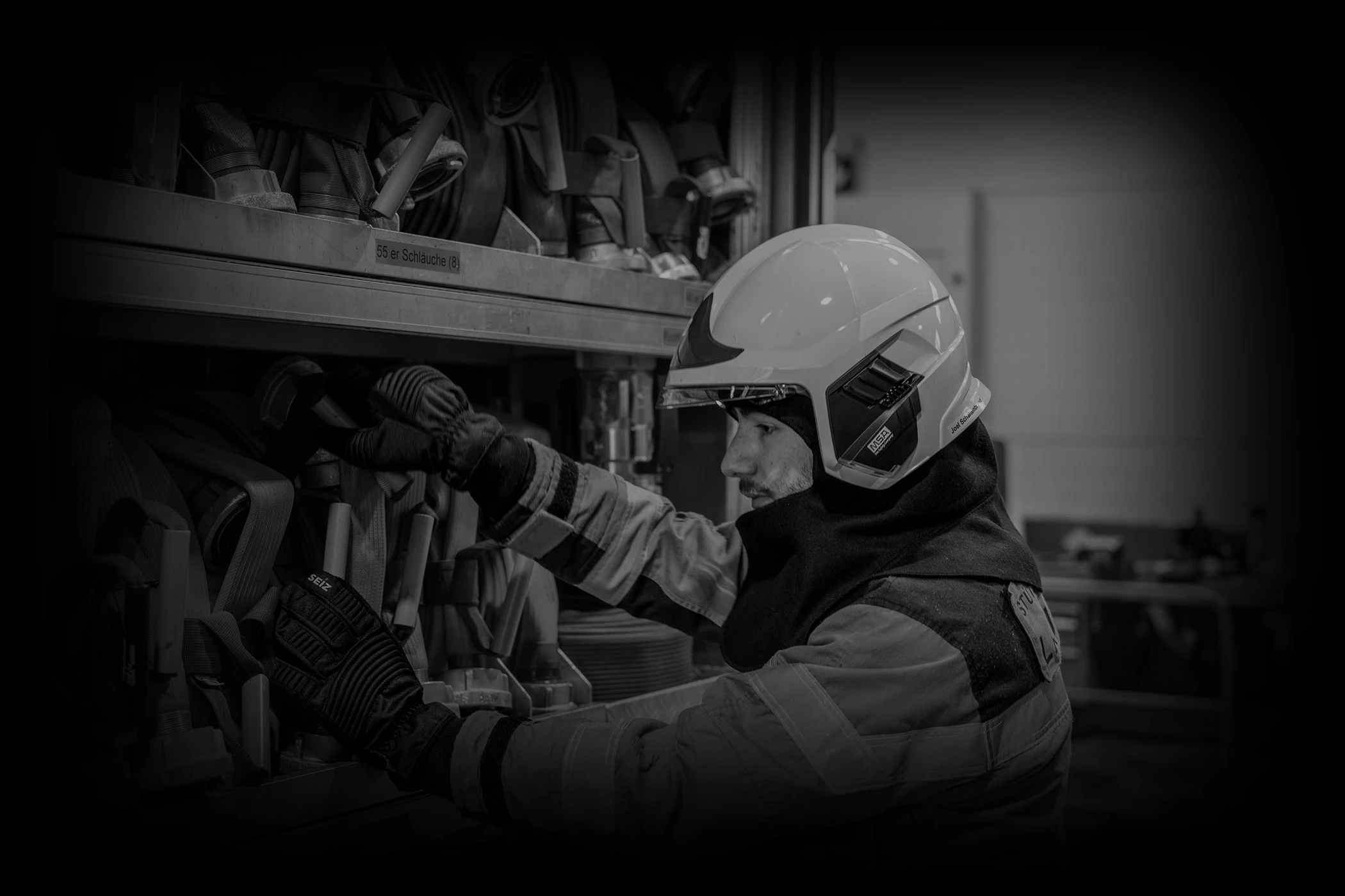 Joel Schaltenbrand, in Feuerwehr Brandschutzkleidung, an einem Feuerwehrfahrzeug.
